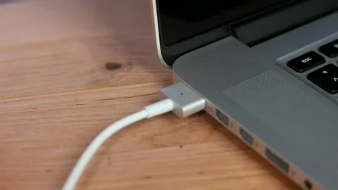 Plugging MagSafe charger cable into Apple MacBook Pro Stock Footage 223375422