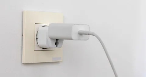 Plugging multiple power plugs into wall outlet Stock Footage 114605281