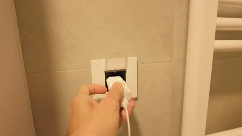 Plugging power cord into wall socket Stock Footage 318106424