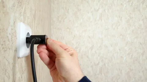 Plugging the power supply unit with cable, cord, wire into the wall socket. Stock Footage 279605636