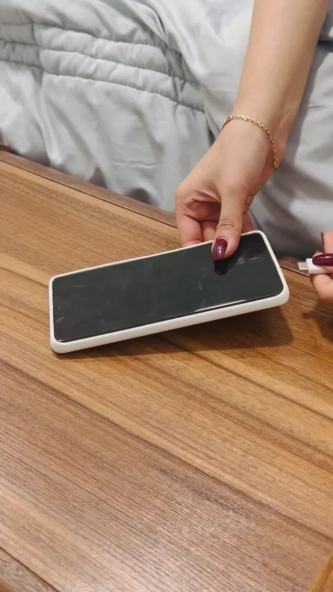Plugging in smartphone for charging, Vídeos de archivo 336848844