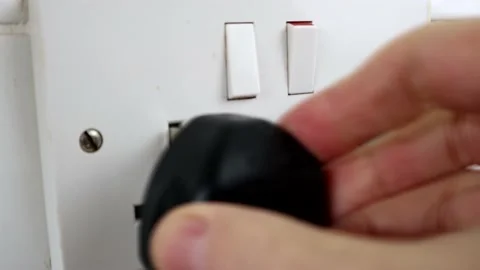 Plugging A UK Plug IN TO a Socket And Switching It On Stock Footage 134728937