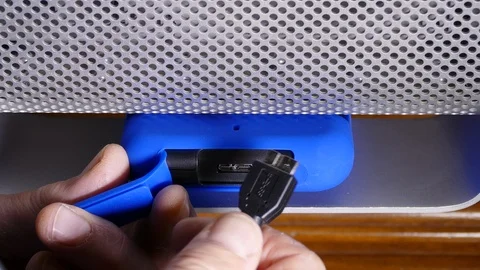 Plugging in a USB cable on an external hard drive/ backup to a computer. Stock Footage 93513772