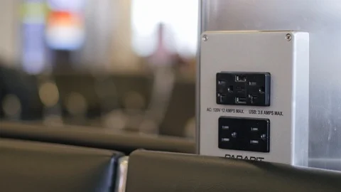 Plugging in usb to charger cell phone at airport Stockbeeldmateriaal 105937381