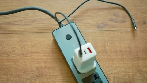 Plugging USB wall charger with Type G UK plug into portable power strip socket 動画素材 333777048