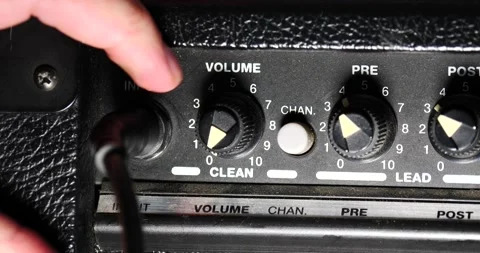 Plugging the wire into the amplifier turning volume up high ready to rock Stock Footage 204959799