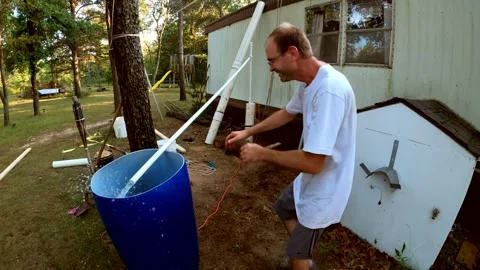 Plugin electric water pump and testing water flow from just finished water well Video stock 162852607