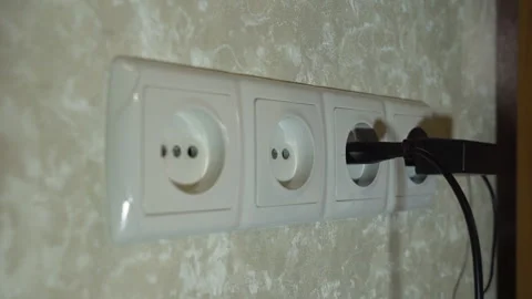 Plugs of electrical appliances are inserted into 4 connected sockets in turn Stock-Footage 259313796