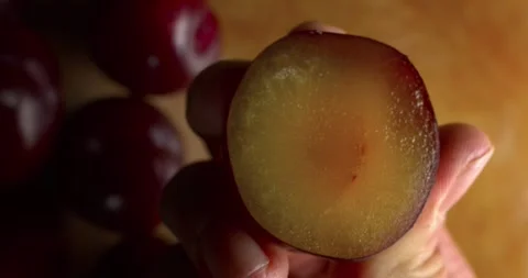 Plum being squeezed with hands close up Stock Footage 302393134