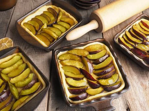 Plum cake prepared for baking on a rustic wooden kitchen table Stock Photos
