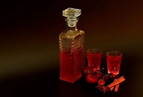 Plum-cherry liqueur with spices in two glasses and a crystal decanter on a .. 스톡 사진