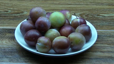 Plum fall on the white plate Stock Footage 79682316
