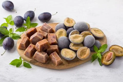 Plum freezing methods: plum puree and plum halves garnished with fresh plum.. Stock Photos