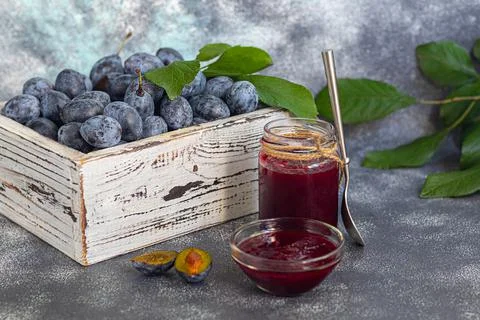 Plum jam in a jar. In the background there are plums. Tkemali sauce. Preparin Fotos de archivo