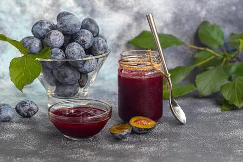 Plum jam in a jar. In the background there are plums. Tkemali sauce. Preparin Fotos de archivo