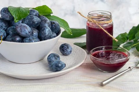 Plum jam in a jar. In the background there are plums. Tkemali sauce. Preparin Stock Photos