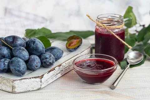 Plum jam in a jar. In the background there are plums. Tkemali sauce. Preparin Stock Photos