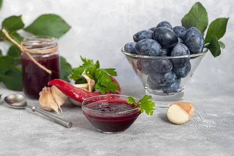 Plum jam in a jar. In the background there are plums. Tkemali sauce. Preparin Stock Photos