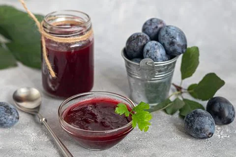 Plum jam in a jar. In the background there are plums. Tkemali sauce. Preparin Fotos de archivo