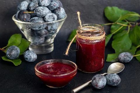 Plum jam in a jar. In the background there are plums. Tkemali sauce. Getting  Stock Photos