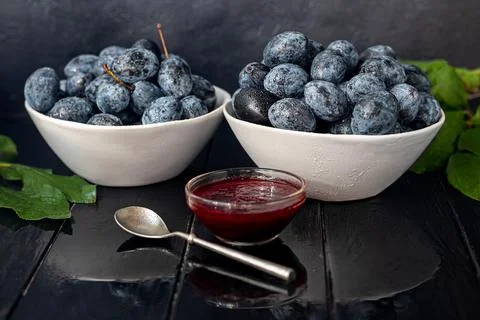 Plum jam in a jar. In the background there are plums. Tkemali sauce. Getting  Fotos de archivo