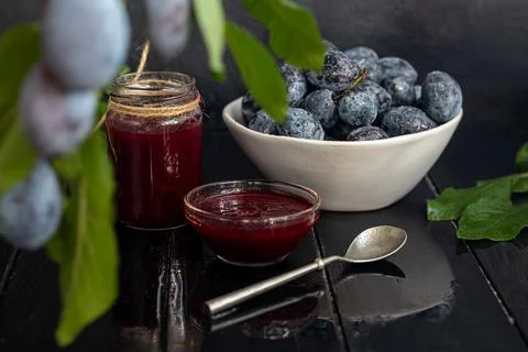 Plum jam in a jar. In the background there are plums. Tkemali sauce. Getting  Fotos de archivo