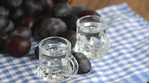Plum liquor in two small glasses. in background rolling fresh plums around. Vídeo Stock 69011507