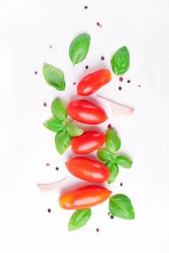 Plum tomato, basil, garlic and pepper on white Stock Photos