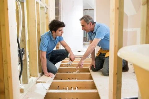 Plumber And Apprentice Fitting Central Heating Stock Photos