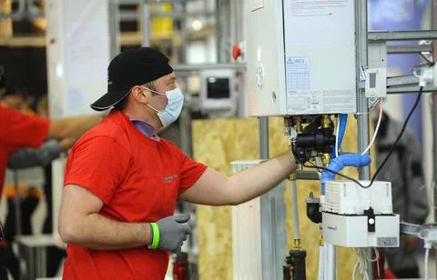 Plumber assembling the boiler Foto stock
