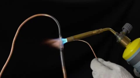 A plumber brazing copper pipe with a propane gas torch in 4K slow motion. Stock Footage 342597237