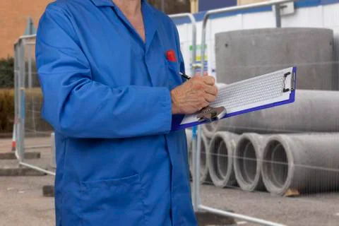 Plumber on a building site checking a data sheet Stock Photos