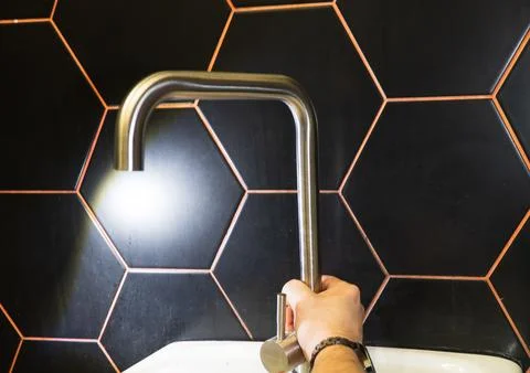 Plumber changes broken, leaking plumbing fixtures in the kitchen. Stock Photos