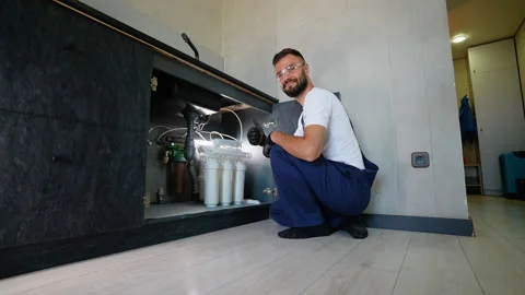 Plumber Changes Water Filters in Reverse Osmosis System Stock Footage 289779672