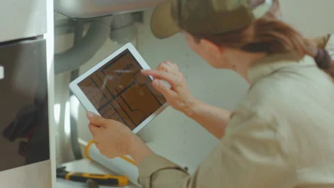 Plumber Cross-Referencing Blueprint on Tablet Stock Footage 309489847