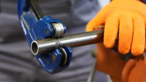 Plumber cuts a metal pipe with a pipe cutter Stock Footage 279074315