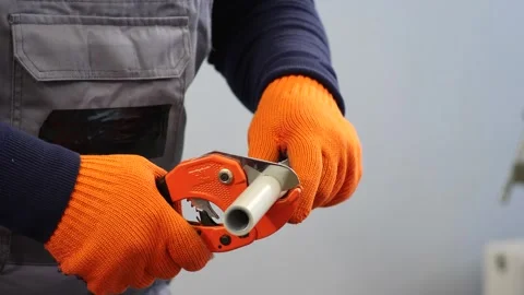 Plumber cuts a plastic pipe with a pipe cutter Stock Footage 279074296