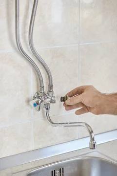 The plumber disassembles the faucet vertical view Stock Photos