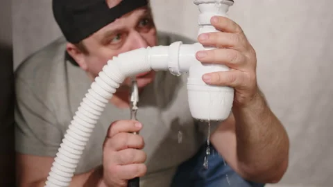 Plumber fixes water leak under sink. Wat... | Stock Video | Pond5