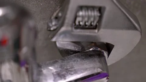 Plumber fixing leaky faucet with adjustable wrench Stock Footage 304118375