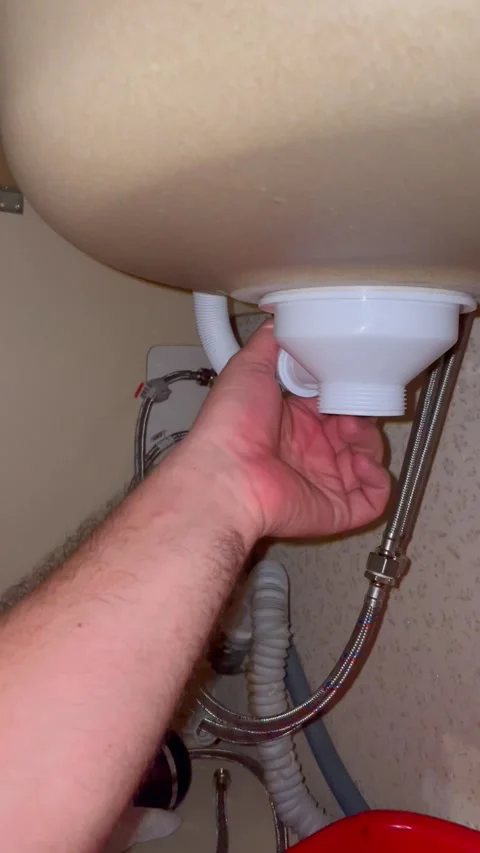 Plumber fixing sink drain pipe under kitchen counter. Man installs plastic Stock Footage 340124671