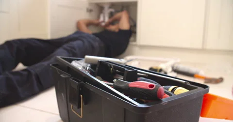 Plumber fixing sink in kitchen, focus on toolbox Stock Footage 56217705