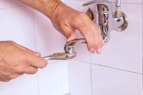 Plumber fixing the tap Stock Photos
