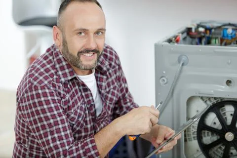 A plumber fixing washing machine Stock Photos