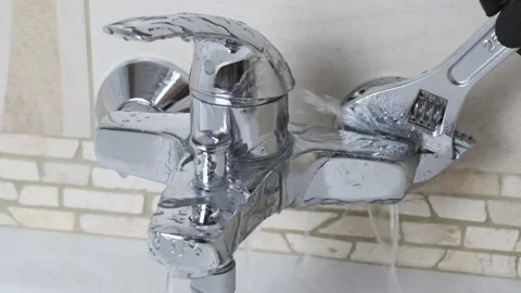 Plumber Fixing a water leaking tap Faucet by Adjustable wrench Stock Footage 135618372