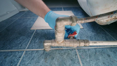 Plumber Hand in Blue Glove Closing Red Ball Valve | Water Supply Pipe Shutoff Stock Footage 341367509