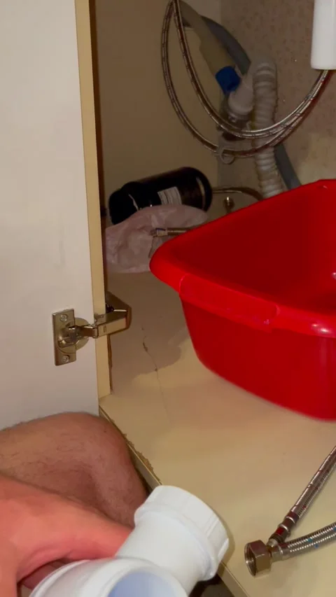 Plumber hands assembling plastic siphon pipe under kitchen sink. Maintenance Stock Footage 340124686