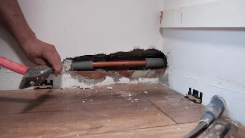 Plumber hands breaking the wall to fix punctured pipe - close up Stock-Footage 154366173