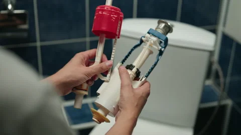 Plumber hands holding and assembling toilet flush mechanism parts, preparing for Stock Footage 318748565