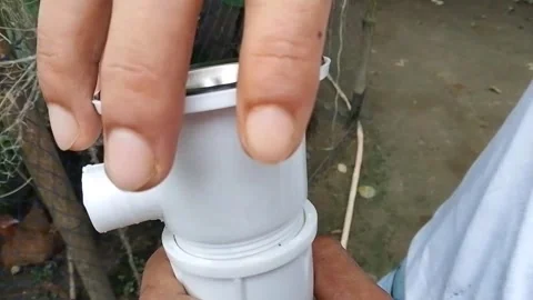 Plumber holding plastic kitchen sink drain waste outlet pipe connection. 스톡 동영상 346617814